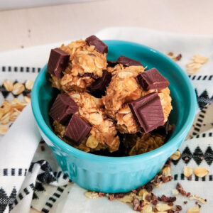 healthy hemp heart chocolate balls in a blue bowl surrounded by oats and cacao nibs