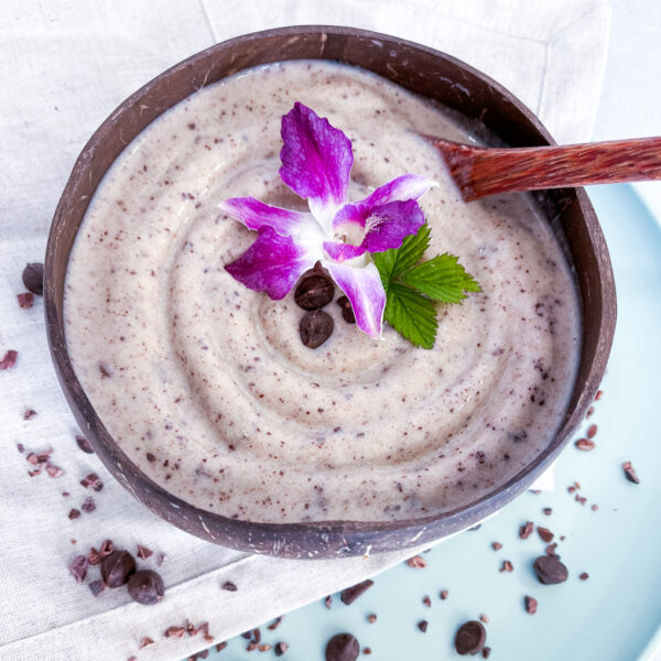 A banana based smoothie bowl with blended oreos topped with chocolate chips and a flower