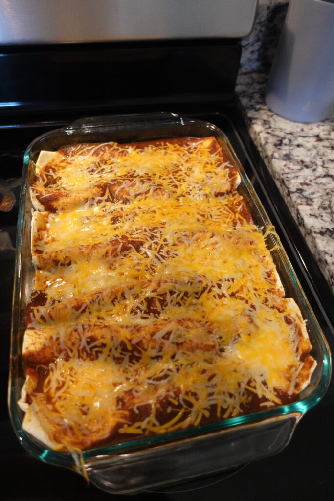 cooked black bean enchiladas topped with a Mexican blend cheese