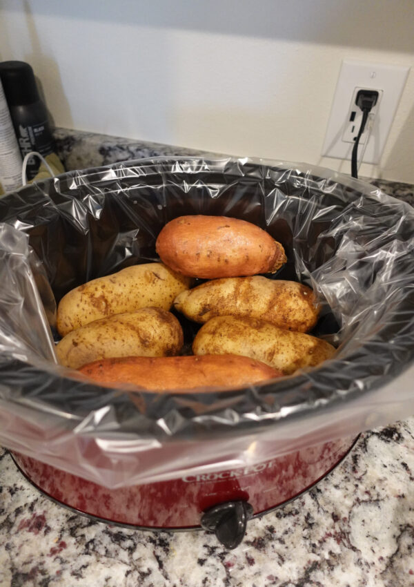 red crockpot with potatoes inside